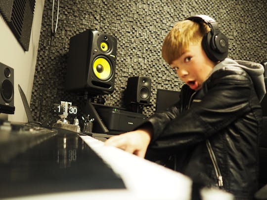 Boy playing piano in the recording studio