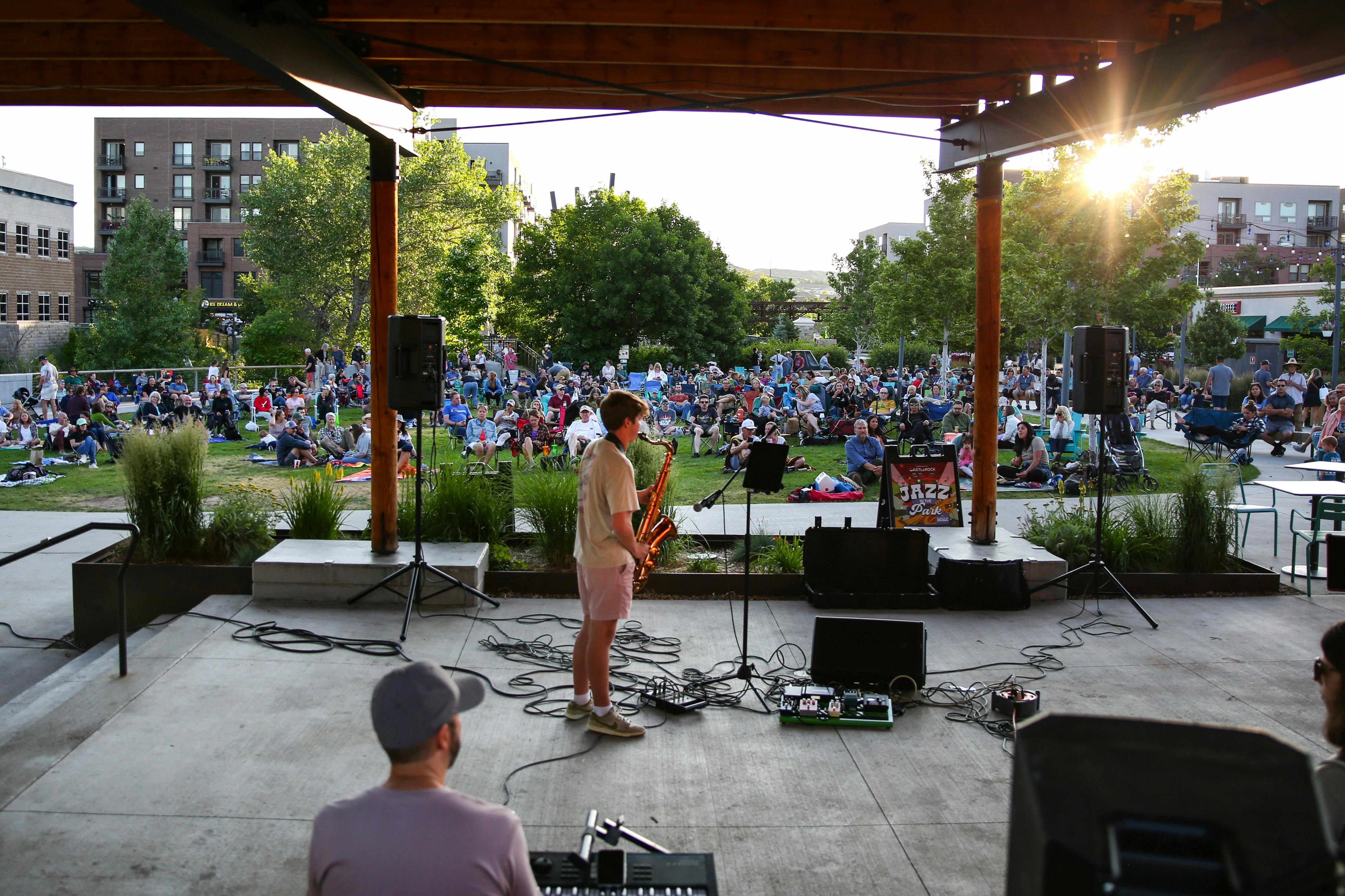 Performance: Student tenor saxophone player and audience at Jazz in the Park, Castle Rock Colorado