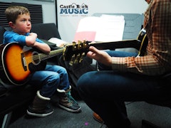 Teacher and student learning guitar
