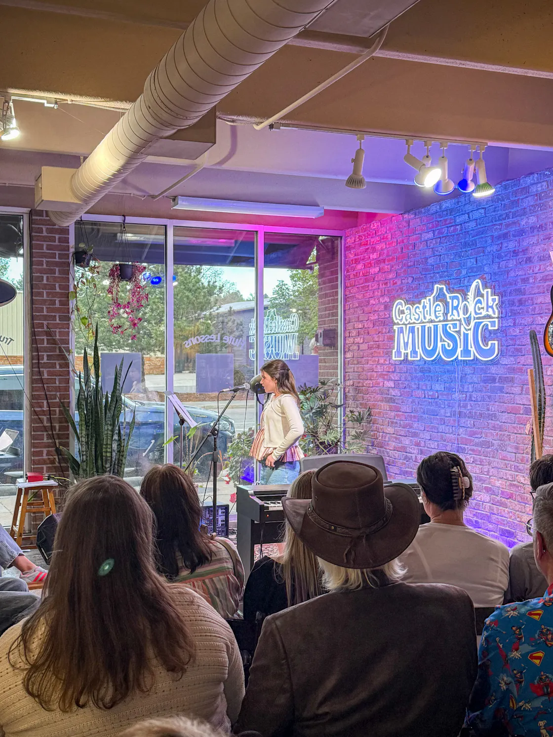 Performance: Student singer with dark hair and audience